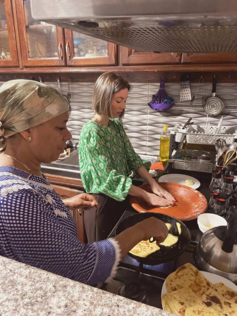 Deux femmes dans une cuisine préparent des Msemmen sur le feu lors d'un cours de cuisine Marrakech.