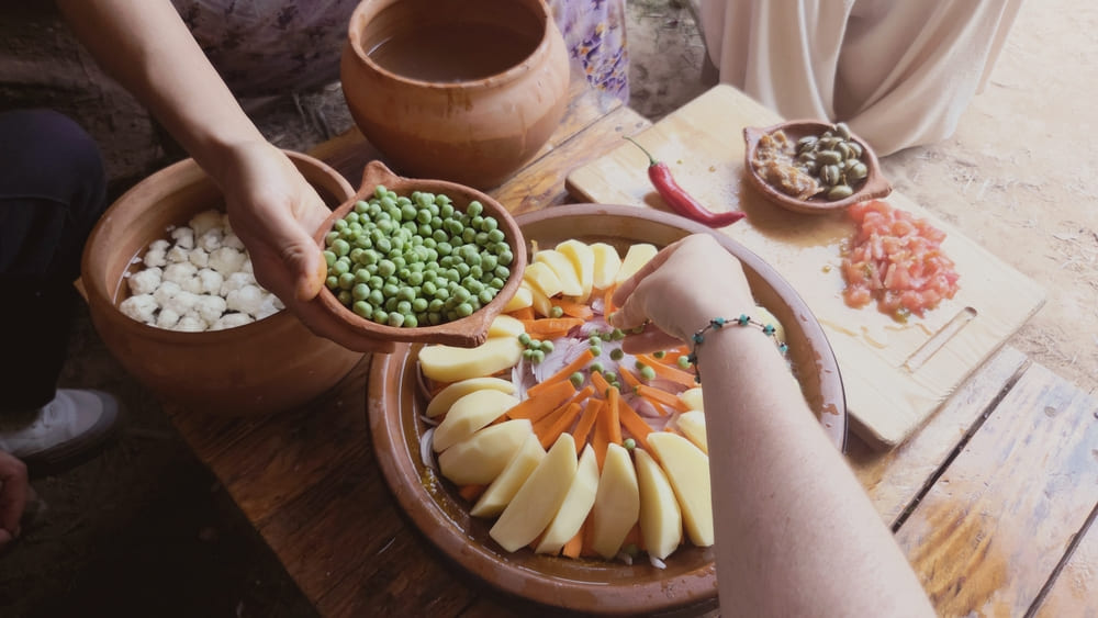 Dressage des legumes dans le tajine traditionnel en cuisine berbere