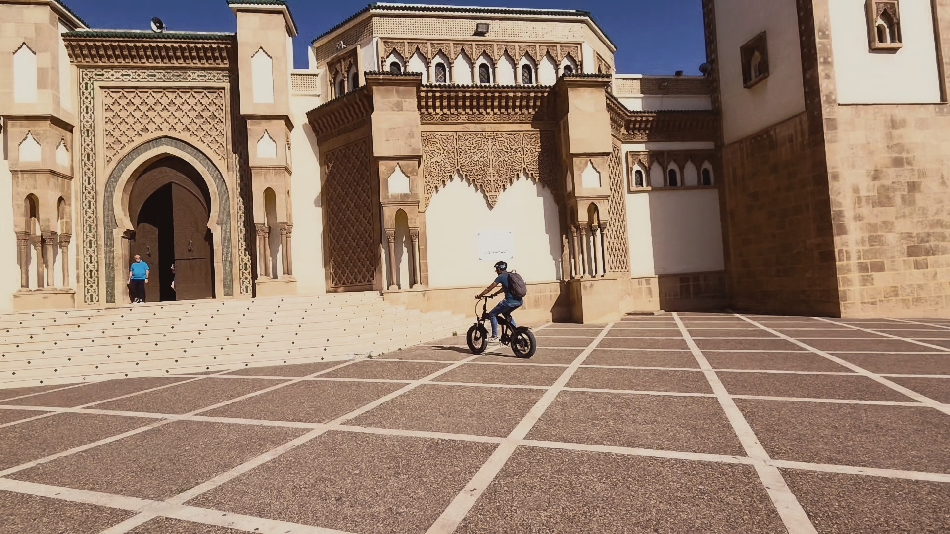 Passage en vélo électrique devant l_architecture traditionnelle d_un monument lors de la visite à Agadir