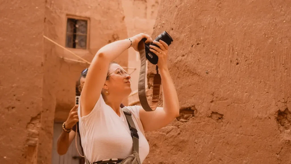 Voyageuse photographiant les ruelles du ksar d'Aït Ben Haddou pendant un photo tour