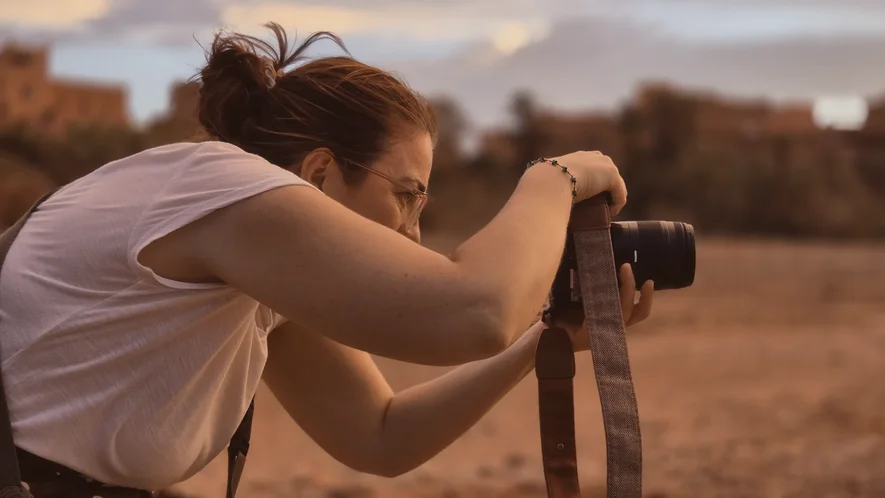 Voyageuse photographiant le ksar d'Aït Ben Haddou au coucher du soleil lors d'un photo tour