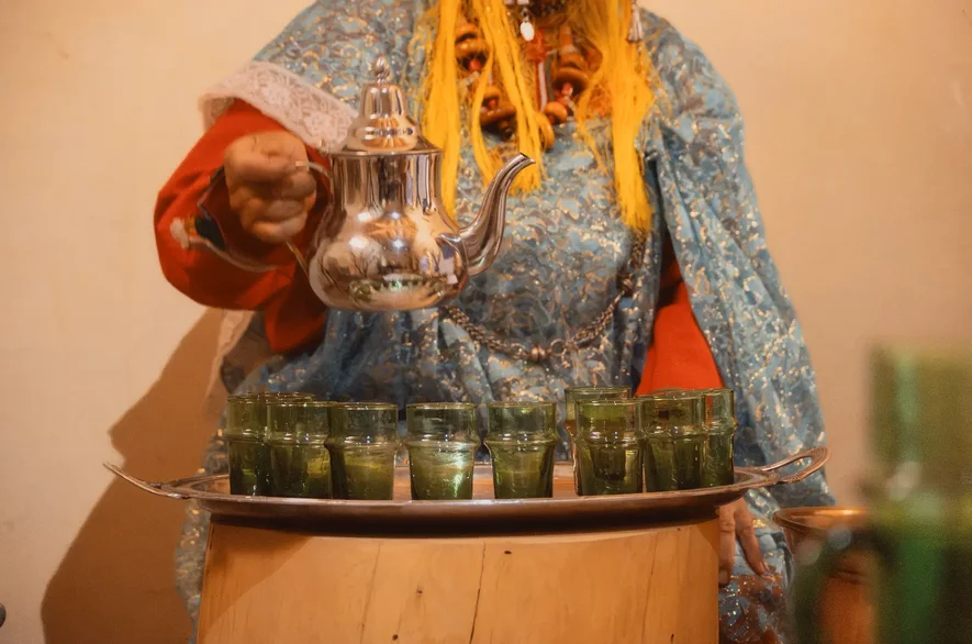 Poétesse amazighe servant le thé à la menthe pendant l'atelier de conte à Aït Ben Haddou