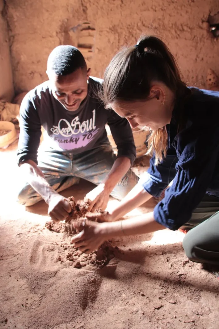 Voyageuse travaillant l'argile avec Mohamed dans son atelier de poterie à Skoura