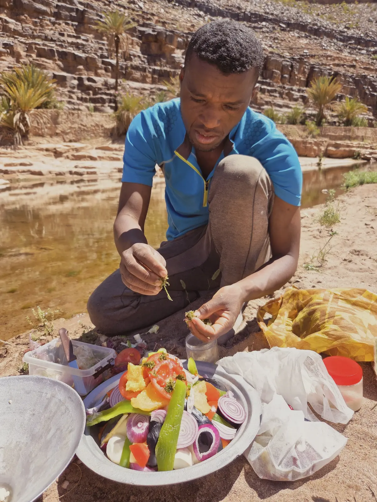 Oasis de Fint près de Ouarzazate : le guide prépare les légumes du tajine au bord de l'oued