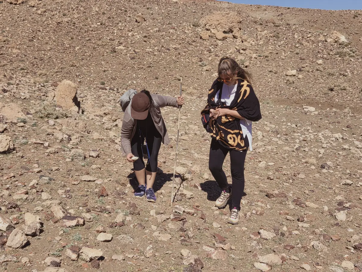 Randonnée Ouarzazate : deux randonneuses cherchent des pierres précieuses sur le versant de la vallée des pierres
